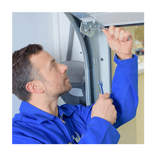 Man working on garage door hinge Man working on garage door hinge
